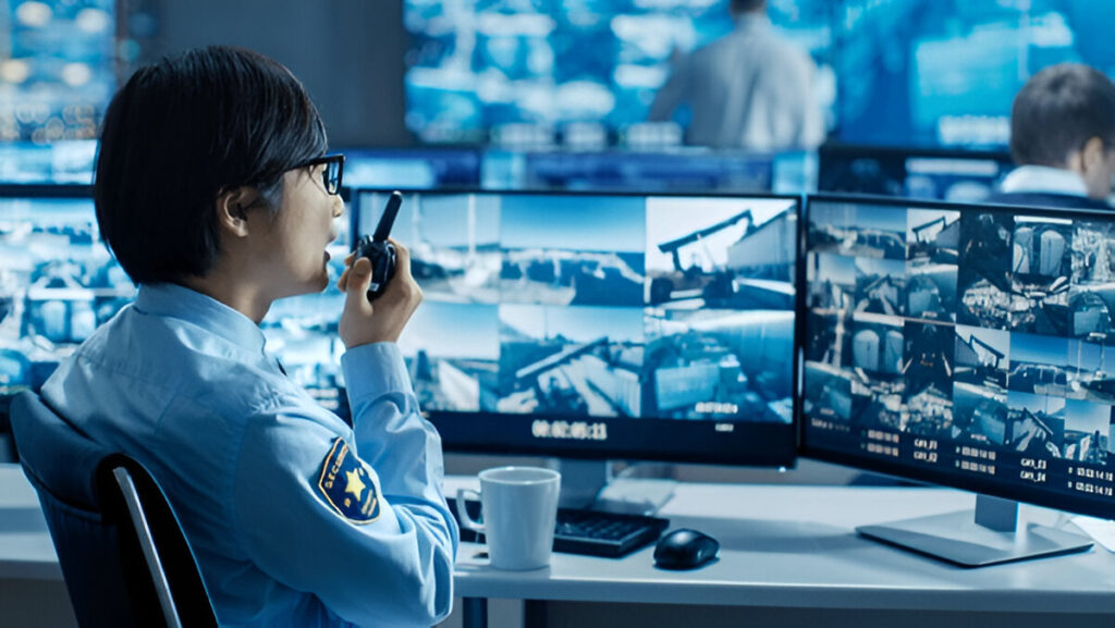 Security worker monitoring live video surveillance footage for real-time threat detection and safety enforcement.